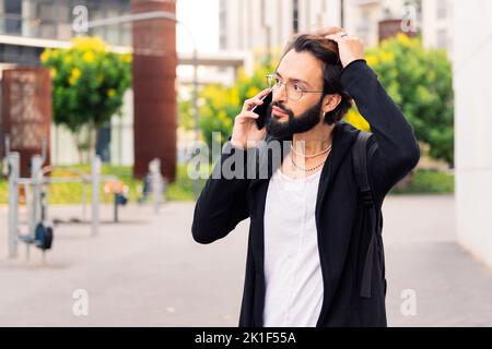 stylish young man talking worried on mobile phone Stock Photo
