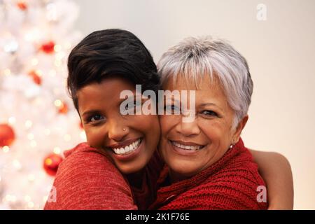 Quality time on Christmas. A senior woman receiving a hug from her daughter on Christmas. Stock Photo