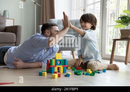 Happy proud dad and cheerful little son boy clapping hands Stock Photo