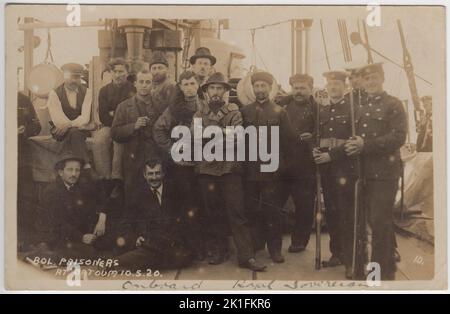 'Bolshevik prisoners at Batoum 10.5.20': photograph of Bolshevik or Communist prisoners on board British Navy battleship HMS Royal Sovereign in May 1920. British servicemen (Royal Marines?) are standing next to the prisoners with fixed bayonets. The HMS Royal Sovereign was at Batoum (now Batumi in Georgia) as part of British involvement in the Russian Civil War following the 1917 Bolshevik Revolution. The prisoners are in a range of clothing - from leather jackets to an embroidered traditional style shirt Stock Photo