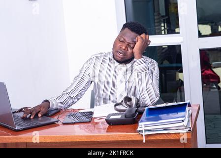 young businessman tired and stressed by work, suffering from headache in office Stock Photo