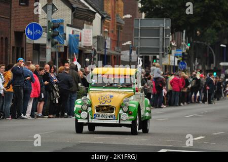 A cute green and yellow Citroen 2CV at the 2017 Tour de France in Meerbusch, Germany with spectators around it Stock Photo