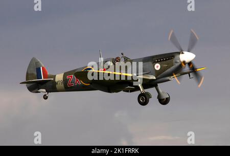 Supermarine Spitfire Mk.VIII, MV154 (G-BKMI) landing at dusk, after it's flying display at the IWM Duxford Battle of Britain Air show 10th September Stock Photo