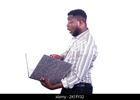 young surprised businessman standing reading files in a filing cabinet in hand. Stock Photo