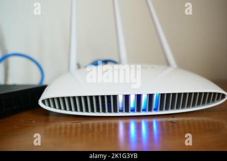 Wi-Fi router with cables on table  Stock Photo
