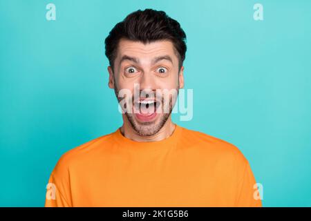 Closeup photo of young handsome impressed funny face guy wear orange t-shirt open mouth excited crazy reaction low prices isolated on cyan color Stock Photo
