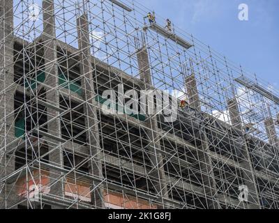Construction workers on scaffolding in the construction of a large new building in San José, Costa Rica. Stock Photo