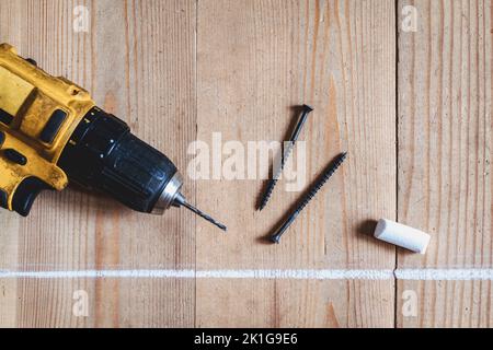 Fixing wooden flooring, screws, chalk and screwdriver, wooden house construction Stock Photo
