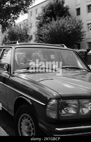 A grayscale vertical shot of a Mercedes W123 TE series S123 in Meerbusch, Germany Stock Photo