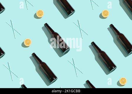 Pattern with brown beer bottles, halves of fresh lemon and drinking straws on blue background. Minimal summer concept. Stock Photo