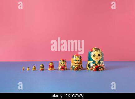Russian dolls also known as matryoshka or babushka stacked on a pink and blue background. Minimal concept. Stock Photo