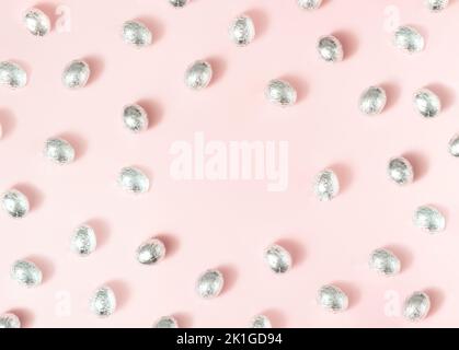 Eggs in aluminium foil on pink background with copy space. Stock Photo