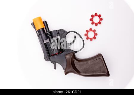 A Closeup shot of a toy pistol revolver with its ammo against a white background Stock Photo