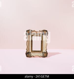 Vintage wooden golden - white empty picture frame on pink background. Minimal concept. Stock Photo