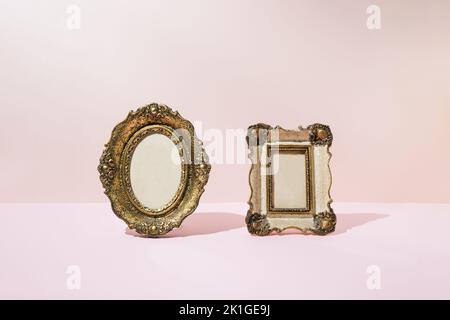 Old vintage empty picture frames on pink background. Copy space. Stock Photo