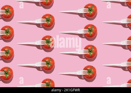 Seamless creative food pattern. Fresh tomatoes with white plastic forks on a pink background. Colourful food concept. Stock Photo