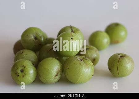 Amla or gooseberries shot on a white background. A translucent green fruit, which derives its name from the Sanskrit word ‘Amlaki’ meaning “nectar of Stock Photo
