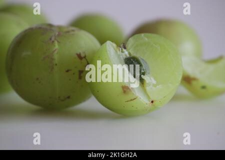 Amla or gooseberries shot on a white background. A translucent green fruit, which derives its name from the Sanskrit word ‘Amlaki’ meaning “nectar of Stock Photo
