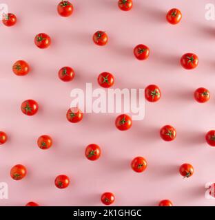 Red cherry tomatoes on the pale pink background. Minimal concept. Stock Photo