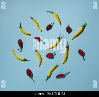 Yellow and red chilli peppers on blue background Stock Photo