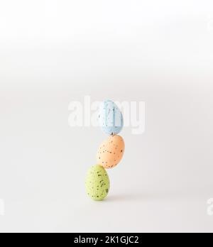 Three colourful styrofoam eggs stacked on white background. Stock Photo