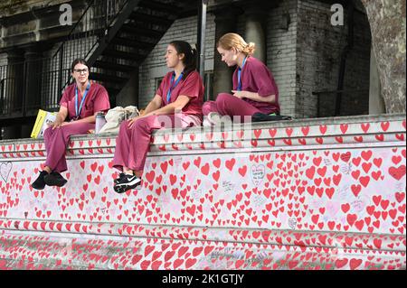 NHS workers sitting on the National Covid Wall, St Thomas's Hospital, Westminster, London. UK Stock Photo