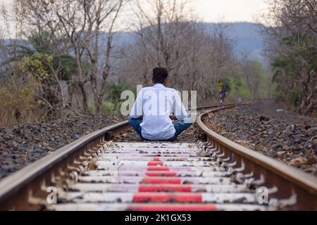 Royalty-Free photo: Man playing a guitar sitting on train rail at daytime |  PickPik
