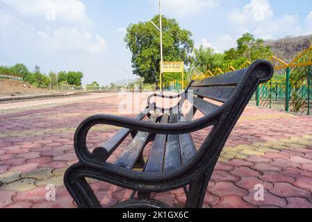 Railway sign board, seating bench at railway station platform of mountain village Kalakund near Mhow, Indore, Madhya Pradesh on a sunny summer day. In Stock Photo