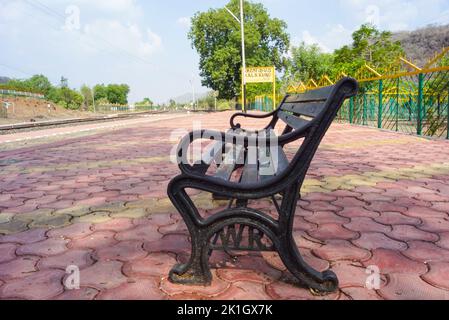 Railway sign board, seating bench at railway station platform of mountain village Kalakund near Mhow, Indore, Madhya Pradesh on a sunny summer day. In Stock Photo