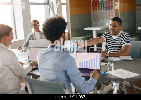 Happy coworkers cooperating and working together at office meeting, teamwork concept Stock Photo