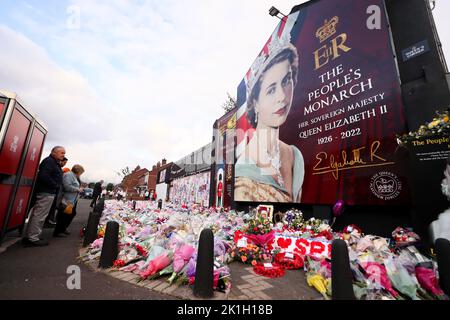 People lays flowers at a mural depicting Queen Elizabeth II on the Shankill Road in Belfast after the British Monarch passed away. Stock Photo