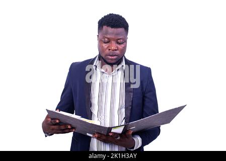 young serious businessman wearing elegant suit and reading documents in the filing cabinet. Stock Photo