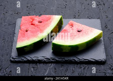 Two slices red and ripe watermelon on slate Stock Photo