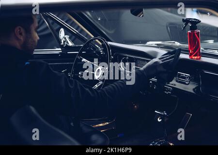 Car detailing or car wash employee cleans the interior of the car Stock Photo