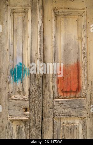 An old wooden door with blue and orange paint on the center. Stock Photo