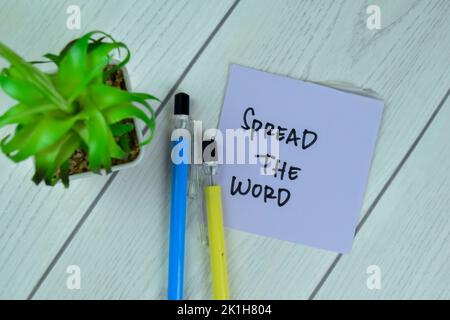 Concept of Spread the word write on sticky notes isolated on Wooden Table. Stock Photo