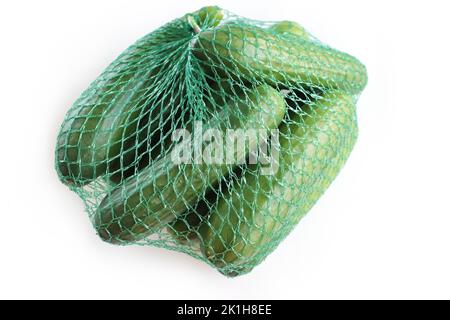 A pile / heap of green cucumbers in the green plastic net mesh / bag. Isolated on the White background. Space for text. Copy space. Top view. Side vie Stock Photo