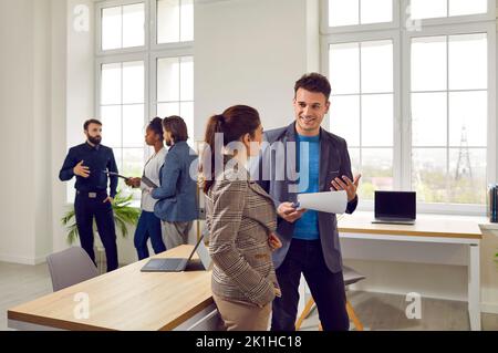 Two business colleagues have friendly conversation about work in coworking office. Stock Photo