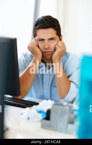 The struggles in the corporate jungle. an angry young businessman pulling a frustrated face. Stock Photo