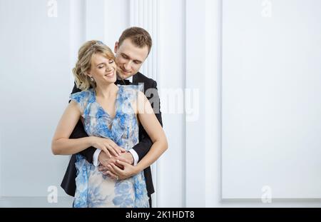 Young couple in luxury fashionable clothes hugging and laughing indoors Stock Photo