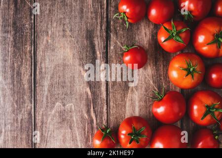 Tomatoes on old wooden table, fresh red tomato vegetables flat lay with copy space Stock Photo