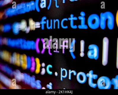 Closeup view of computer code displayed on pixelated screen with bright colorful words on a dark background Stock Photo