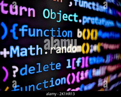 Closeup of computer software code on a digital screen with colorful characters displayed in dark mode on a black background Stock Photo