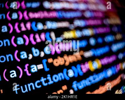 Closeup view of software code on a computer screen with blurred background words Stock Photo