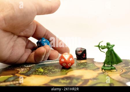 A hand throwing rpg dices on a adventure tile Stock Photo