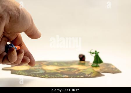 A hand throwing rpg dices on a adventure tile Stock Photo