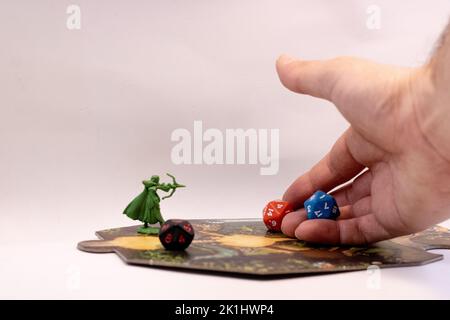 A hand throwing rpg dices on a adventure tile Stock Photo