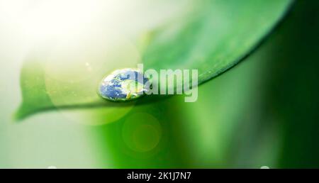 Life-giving water. Closeup shot of the earth reflected in a water droplet on a leaf. Stock Photo