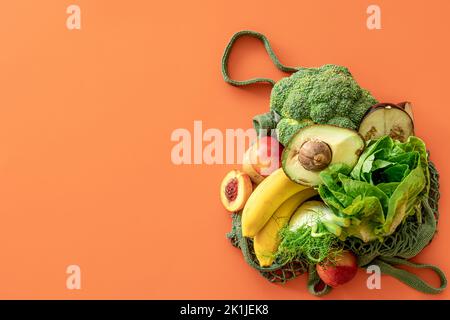 Fresh fruits and vegetables on a colored background, flat lay. Stock Photo
