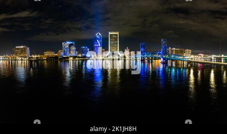 The illuminated waterside buildings of Jacksonville under the cloudy night sky Stock Photo